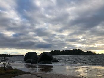 Rocks on sea against sky during sunset