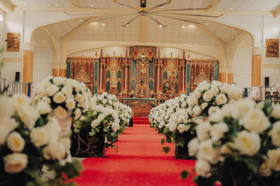 Church wedding design with white flowers designs and red carpet. beautiful church interior design.