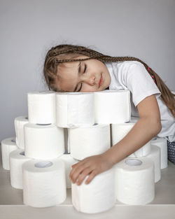 Close-up of smiling girl with toilet paper on table