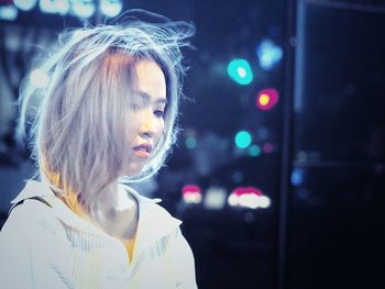 Thoughtful woman standing outdoors at night