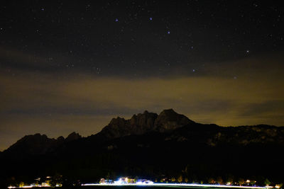 Scenic view of illuminated mountains against sky at night