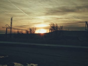 Silhouette electricity pylon against sky during sunset