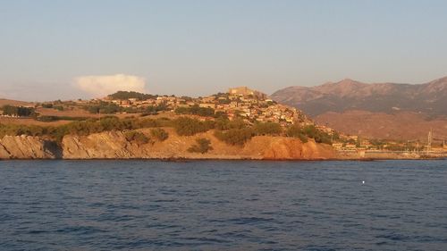 Scenic view of sea and mountains against sky