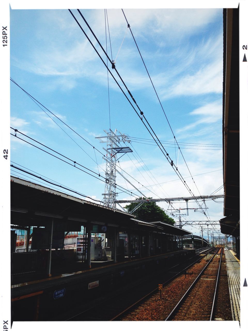 railroad track, transportation, rail transportation, sky, power line, public transportation, railroad station platform, railroad station, built structure, architecture, electricity pylon, connection, train - vehicle, transfer print, cable, building exterior, power supply, cloud - sky, mode of transport, electricity