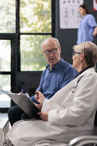 Side view of doctor examining patient in office