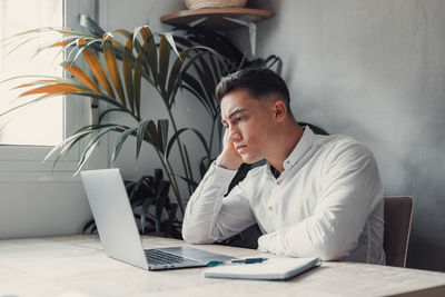 Young man using laptop at table