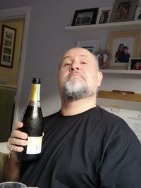 Midsection of man drinking beer in glass