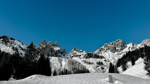 Scenic view of snowcapped mountains against clear blue sky