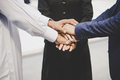 Midsection of business people stacking hands