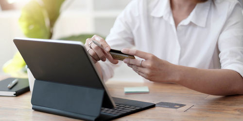 Midsection of man using laptop on table