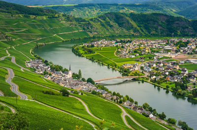 High angle view of river amidst town and green landscape