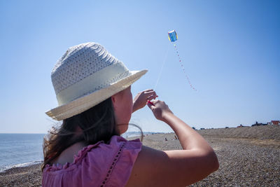 Close-up of girl at beach against sky