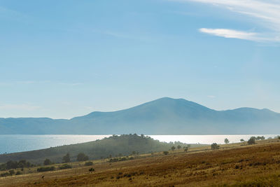 Scenic view of field and mountains against sky