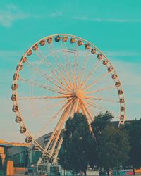 Low angle view of ferris wheel against blue sky