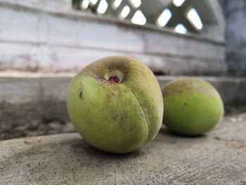 Close-up of peach lying on wall