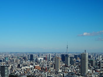 Aerial view of city against blue sky