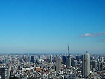 Aerial view of city against blue sky