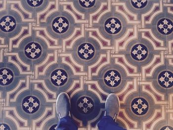 Low section of person standing on tiled floor