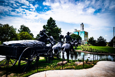 View of horse sculpture by trees against sky