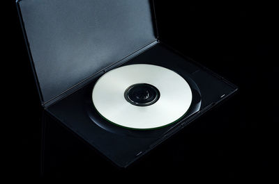 Close-up of compact disc over black background