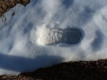 High angle view of footprints on snow covered field