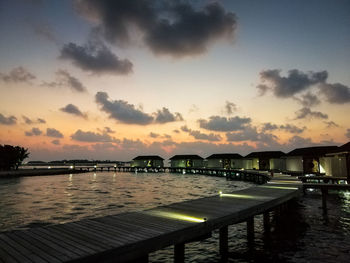 Pier over lake against sky during sunset