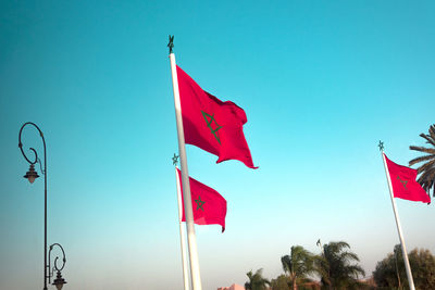 Low angle view of flag against clear blue sky