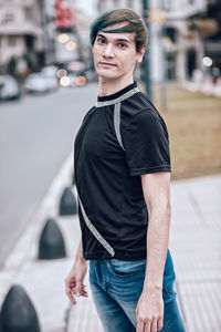Portrait of young man standing in city