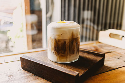 Iced coffee with milk foam and spice on top.