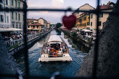 People in canal amidst buildings in city