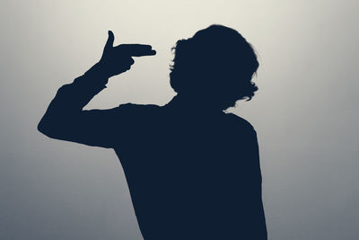 Silhouette man with arms raised