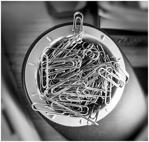 Directly above shot of paper clips in container on table