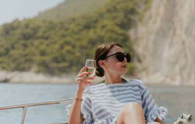 Portrait of a young girl drinking champagne in a boat.