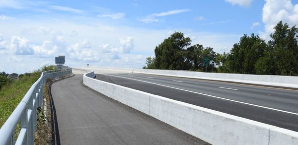 Road by railing against sky