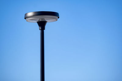 Low angle view of street light against blue sky