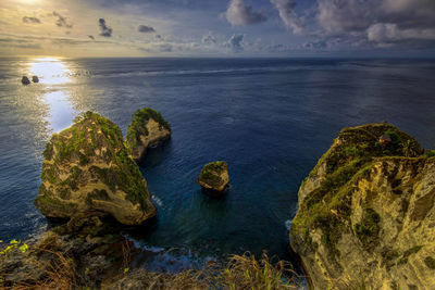 Scenic view of rocks in sea against sky