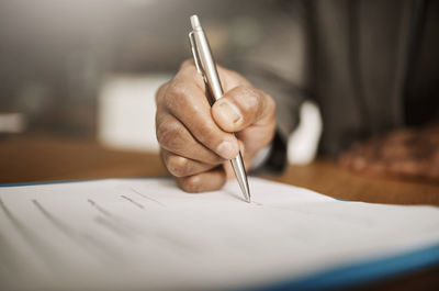 Midsection of woman writing in book