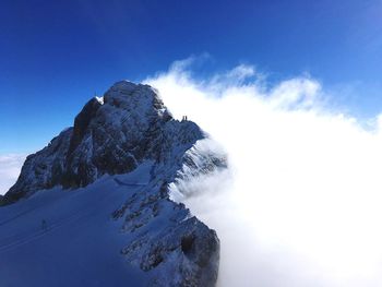 Low angle view of snowcapped mountain against blue sky. dachstein, austria. 