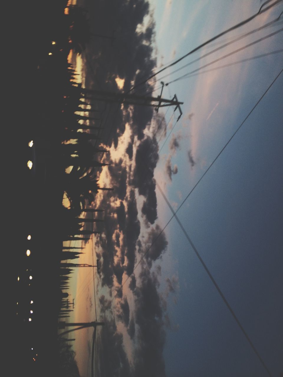 power line, electricity, electricity pylon, cable, sky, power supply, silhouette, building exterior, connection, street light, dusk, power cable, cloud - sky, sunset, built structure, low angle view, architecture, illuminated, tree, technology