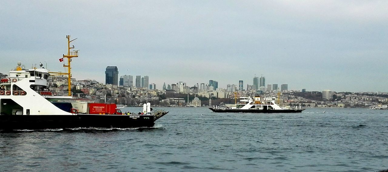 nautical vessel, transportation, mode of transport, water, urban skyline, city, outdoors, no people, sailing, cityscape, building exterior, sea, harbor, commercial dock, shipping, industry, day, architecture, skyscraper, sky