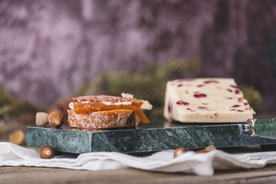 Wensleydale cheese with cranberries on a marble cheese cutting table.