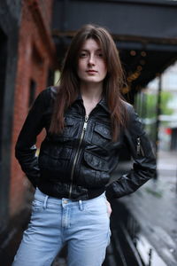 Portrait of beautiful young woman standing on sidewalk