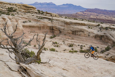 Man riding bicycle on rocky mountains
