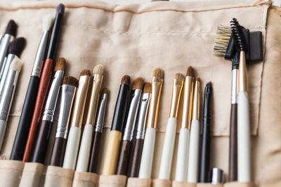 High angle view of paintbrushes in shelf