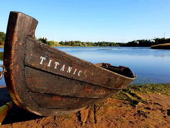 Abandoned boat moored on lake against sky