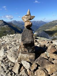 Stack of rocks on mountain against sky