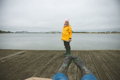 Portrait of girl standing on pier over lake