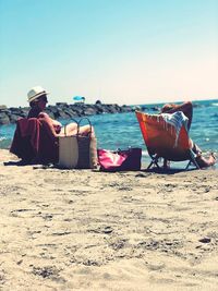 Rear view of people sitting on beach