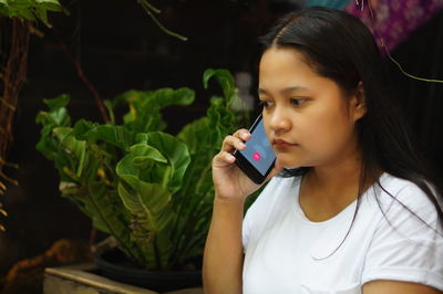 Woman looking away while talking on mobile phone