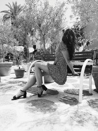 Side view of woman sitting on swimming pool